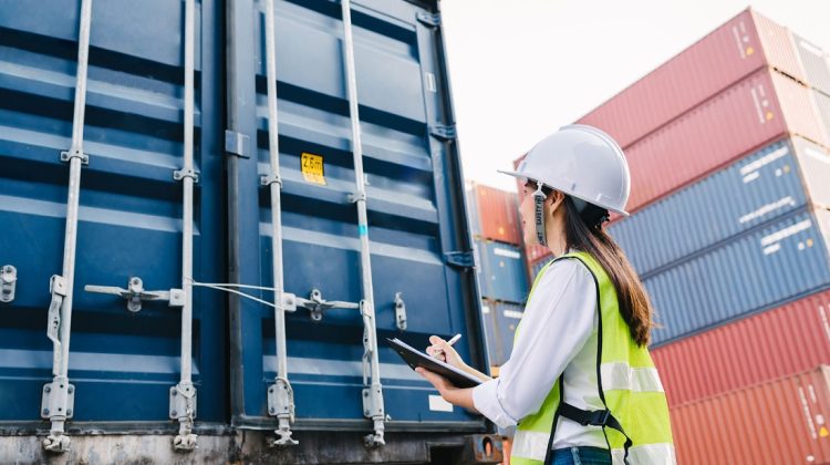 Operadora logistica analizando contenedor de mercancias