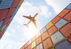 Avion volando sobre contenedores de mercancias