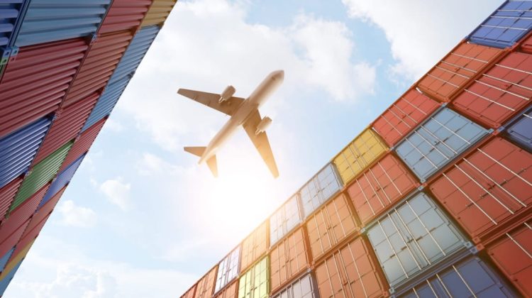 Avion volando sobre contenedores de mercancias
