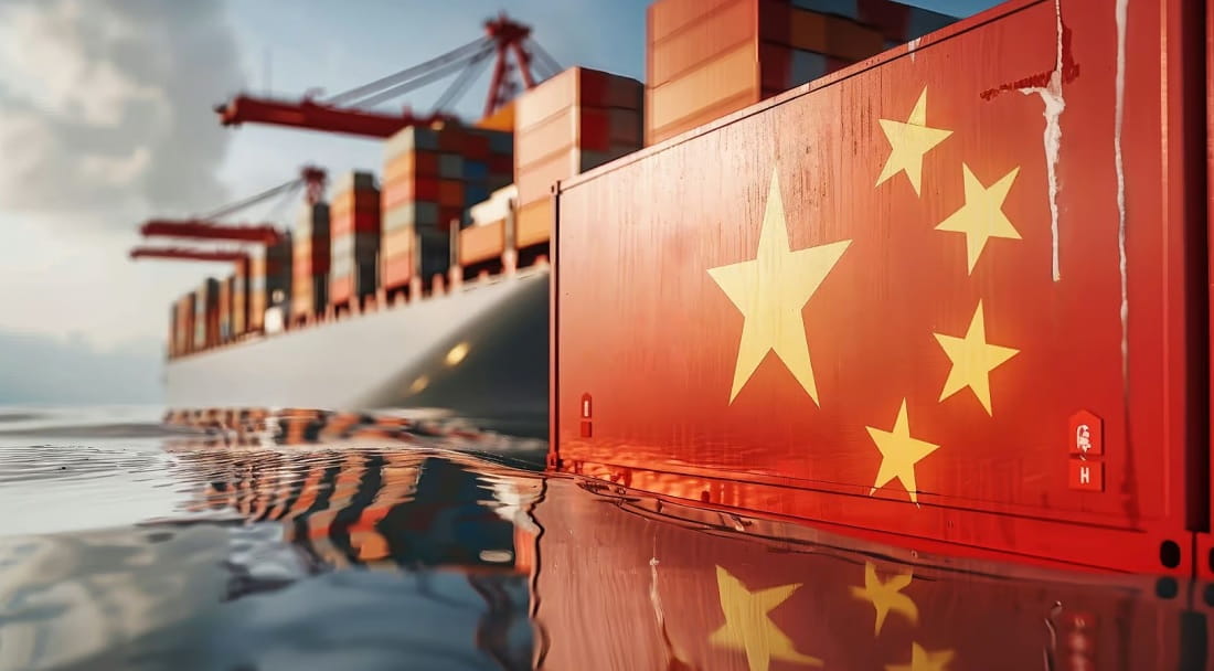 Bandera de china flotando sobre el agua con un buque de carga detrás