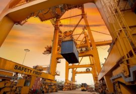 Grúa pórtico levantando un contenedor en una terminal portuaria de carga