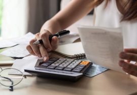 Persona usando una calculadora para calcular costos