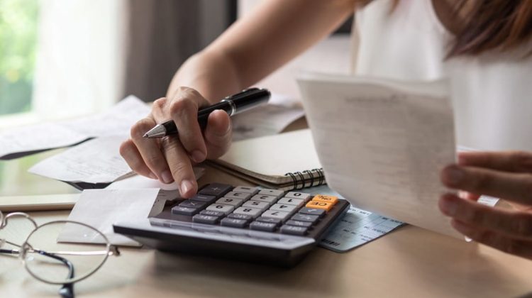 Persona usando una calculadora para calcular costos