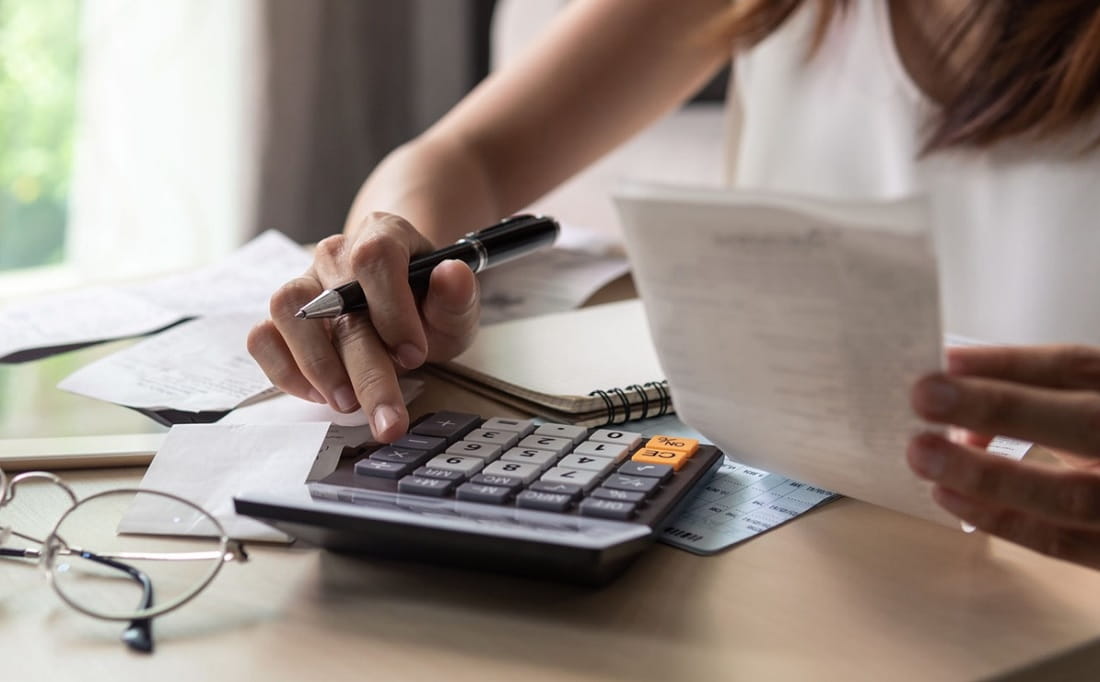 Persona usando una calculadora para calcular costos
