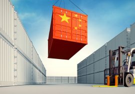 Contenedor de carga con bandera de china siendo bajado por maquinaria industrial
