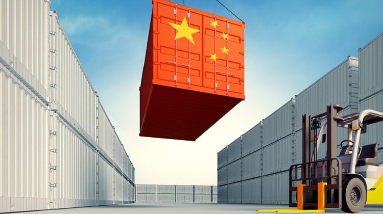 Contenedor de carga con bandera de china siendo bajado por maquinaria industrial